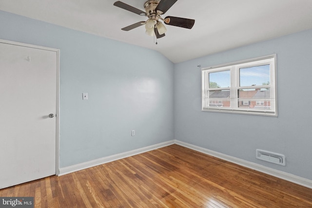 unfurnished room featuring ceiling fan, baseboards, wood finished floors, vaulted ceiling, and visible vents