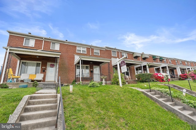 view of property with brick siding and a front lawn
