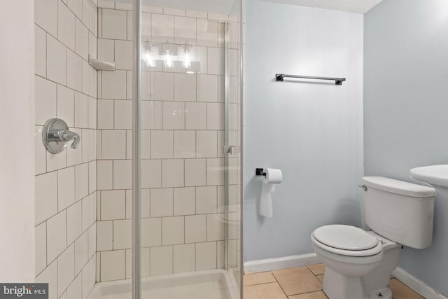 full bath featuring baseboards, tile patterned floors, a stall shower, and toilet
