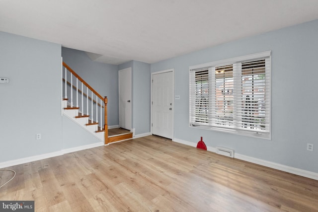 entryway featuring baseboards, stairs, wood finished floors, and visible vents