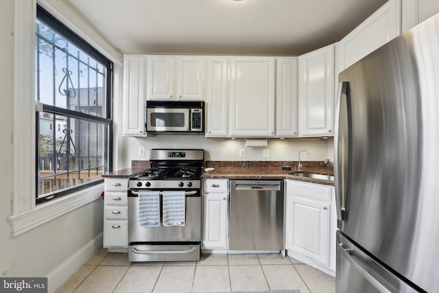 1619 Marion St NW, Washington, DC 20001 - kitchen featuring appliances with stainless steel finishes, a sink, light tile patterned floors, and white cabinets