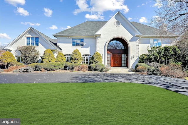 view of front facade featuring a front yard and brick siding