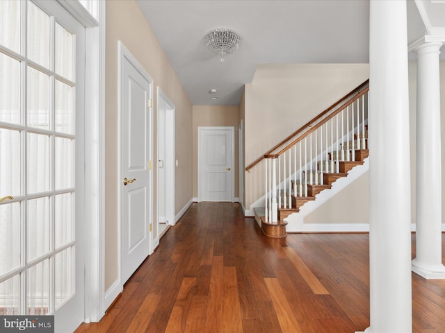 entrance foyer featuring stairs, baseboards, ornate columns, and hardwood / wood-style flooring