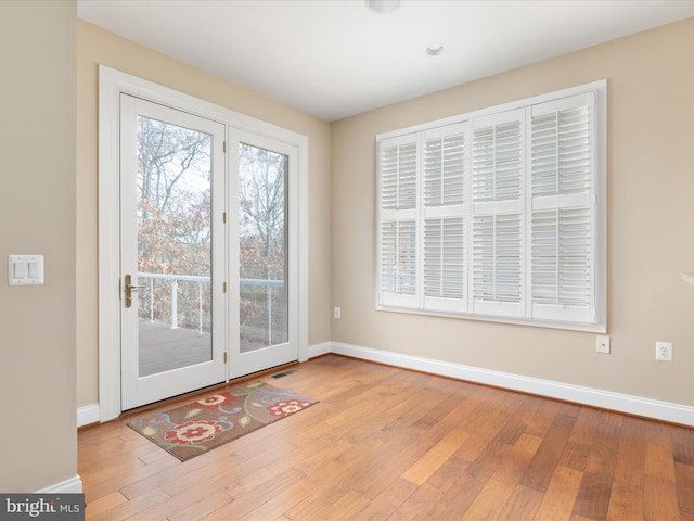 entryway with wood finished floors, visible vents, and baseboards