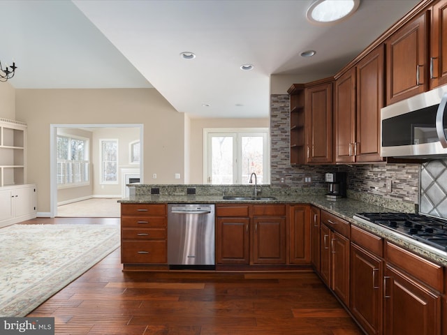 kitchen with decorative backsplash, appliances with stainless steel finishes, dark wood finished floors, and a sink