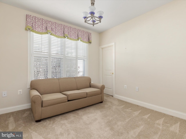 sitting room with carpet flooring, a notable chandelier, and baseboards