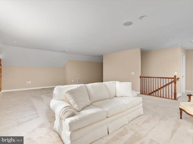 carpeted living room with vaulted ceiling, visible vents, and baseboards