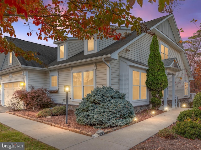 view of front of house with a garage and a shingled roof