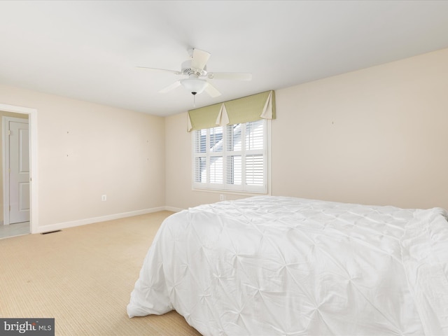 bedroom featuring baseboards, ceiling fan, visible vents, and light colored carpet