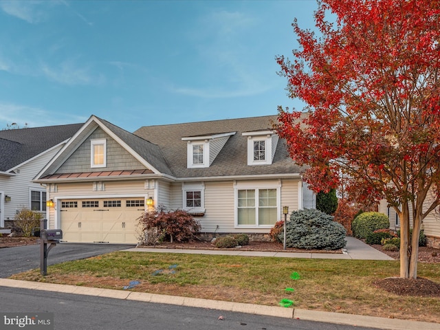 view of property with a garage, driveway, a front yard, and roof with shingles