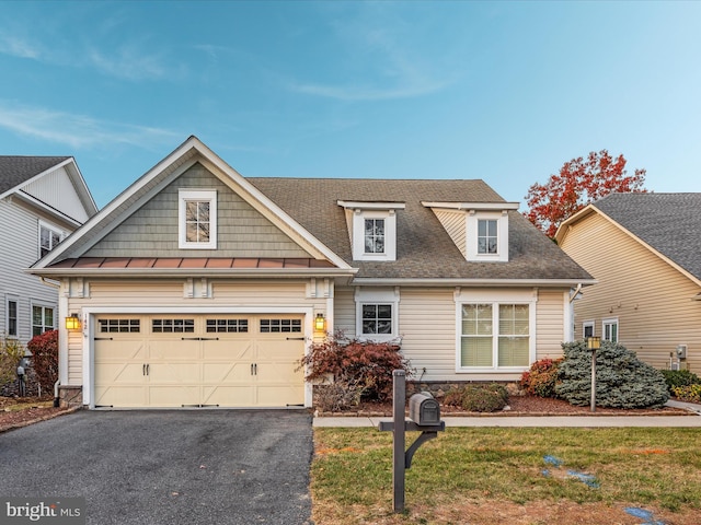 view of front of house with driveway, a shingled roof, a garage, and a front yard