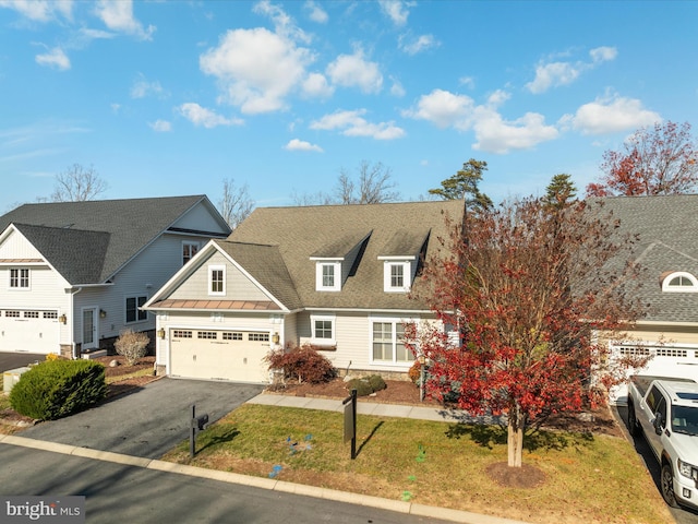 view of front of home with driveway, roof with shingles, and an attached garage