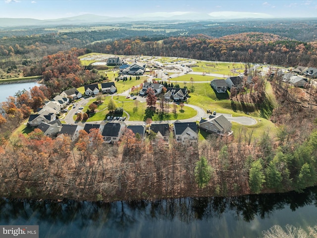 bird's eye view with a water view and a wooded view