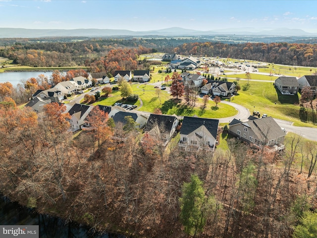 drone / aerial view featuring a water view, a forest view, and a residential view