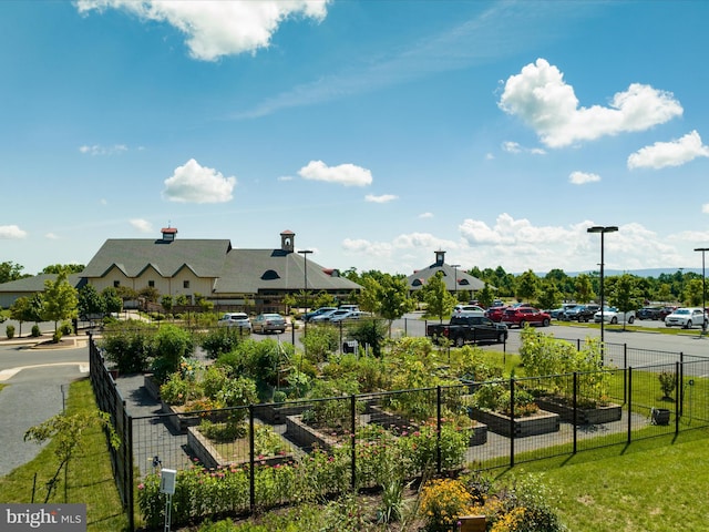 view of property's community with a garden, fence, and a yard