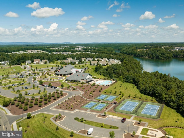 birds eye view of property with a water view and a wooded view