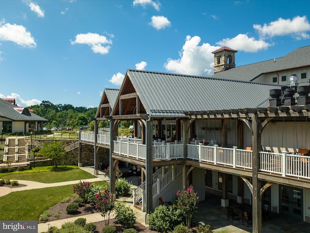 back of property featuring metal roof, stairs, a deck, a patio area, and board and batten siding