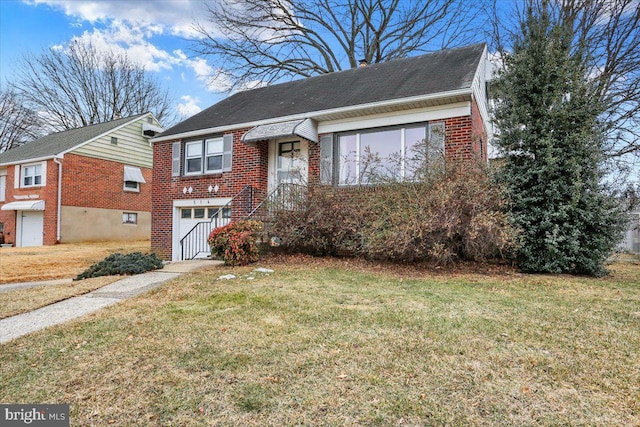 view of front of property with an attached garage, a front lawn, and brick siding