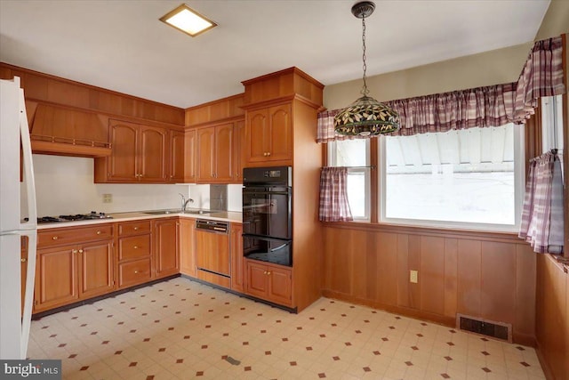 kitchen featuring oven, visible vents, freestanding refrigerator, light floors, and paneled dishwasher