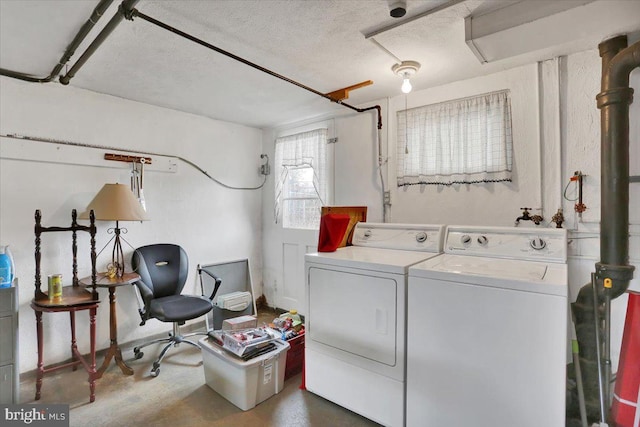 laundry area with laundry area, a textured ceiling, and washer and dryer