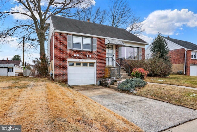 view of front of property featuring a garage, brick siding, driveway, a chimney, and a front yard