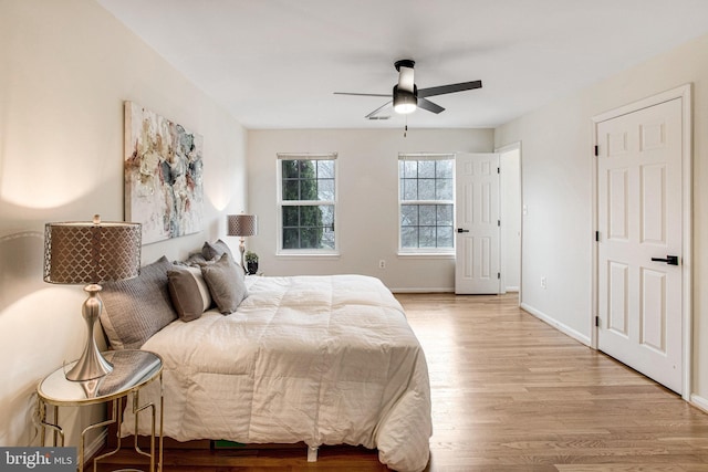 bedroom featuring ceiling fan, visible vents, baseboards, and wood finished floors