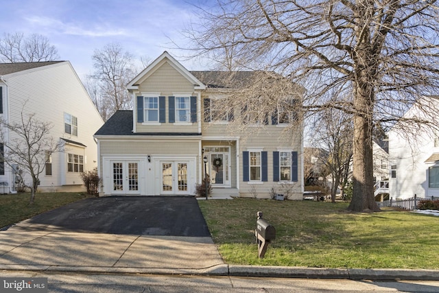 view of front of property featuring a shingled roof, french doors, driveway, and a front lawn