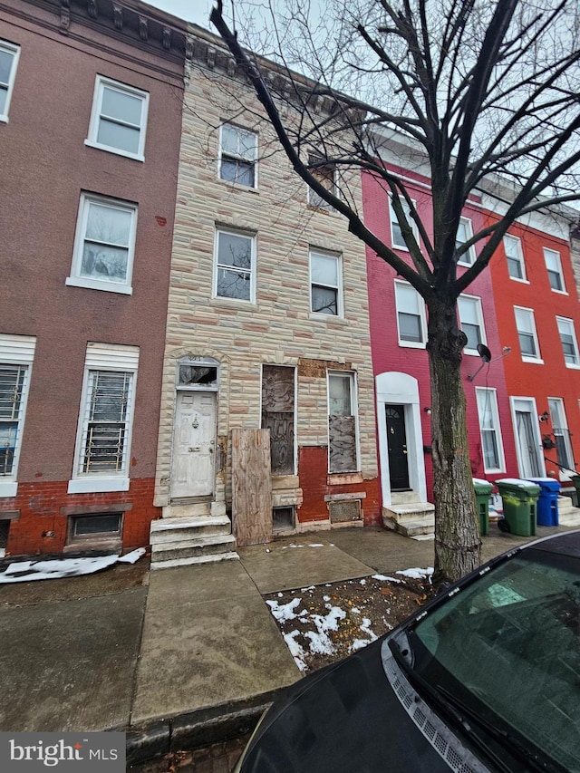 townhome / multi-family property with entry steps and stone siding