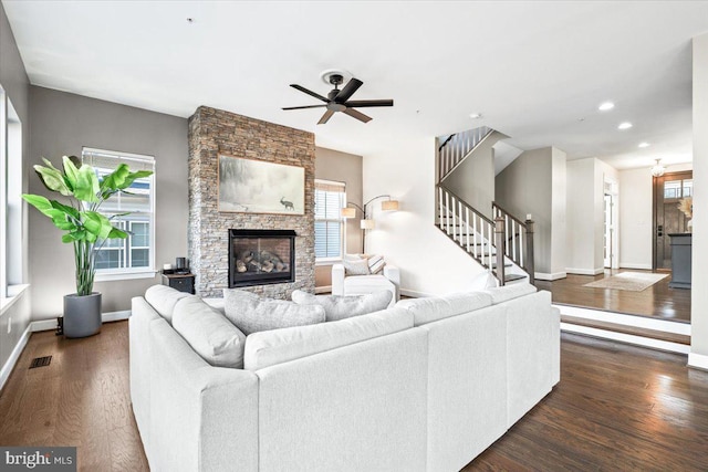 living area with stairs, dark wood-type flooring, a fireplace, and baseboards