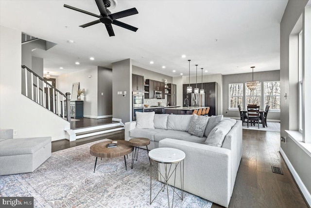 living room with stairway, recessed lighting, visible vents, and wood finished floors