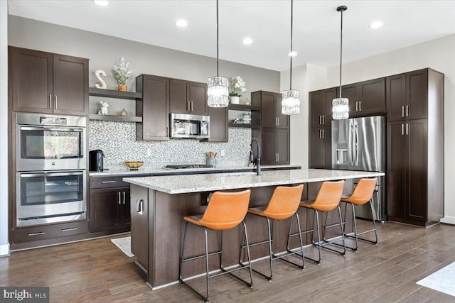 kitchen with open shelves, dark brown cabinets, wood finished floors, and appliances with stainless steel finishes