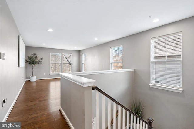 hall with an upstairs landing, dark wood-style floors, recessed lighting, and baseboards