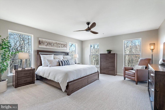 carpeted bedroom featuring baseboards and a ceiling fan