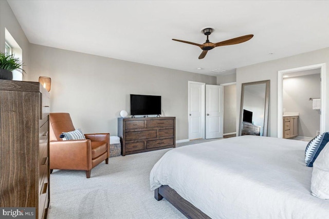 bedroom featuring baseboards, light carpet, ensuite bath, and a ceiling fan