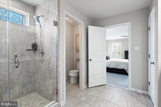 full bath with tile patterned floors, toilet, a stall shower, ensuite bathroom, and baseboards