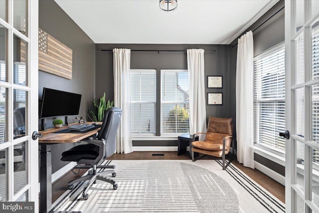 home office with plenty of natural light, french doors, baseboards, and wood finished floors