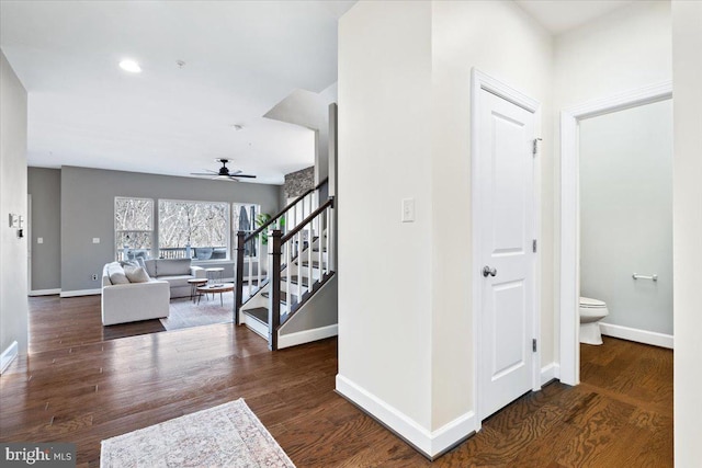 interior space featuring baseboards, wood finished floors, and stairs