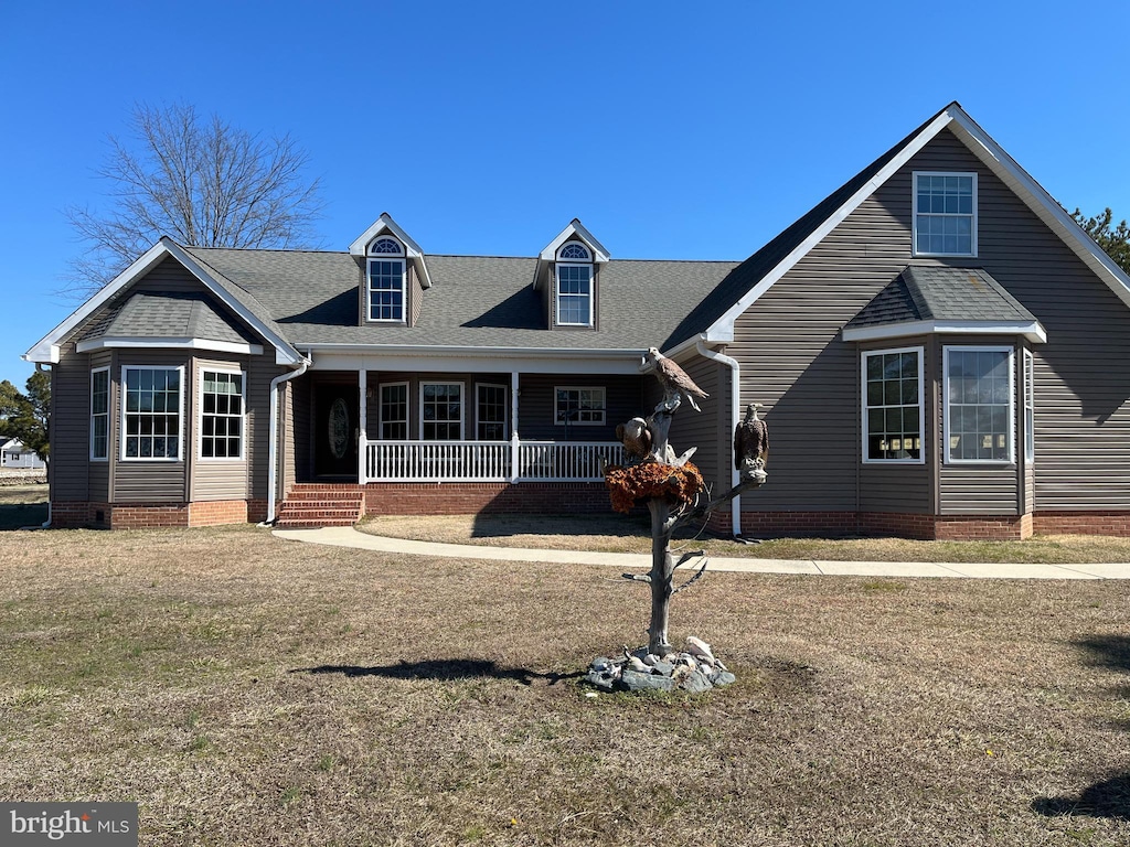 cape cod home featuring crawl space, covered porch, roof with shingles, and a front yard