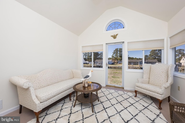 living area with high vaulted ceiling and baseboards