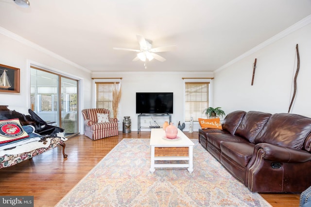 living area featuring plenty of natural light, wood finished floors, and ornamental molding