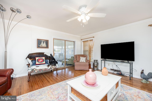 living room with crown molding, wood finished floors, and baseboards