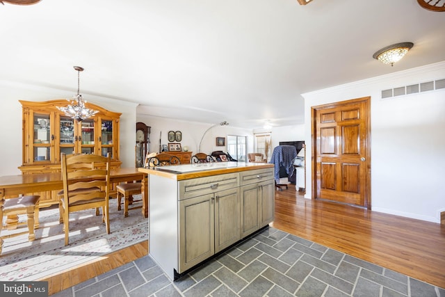 kitchen featuring visible vents, dark wood finished floors, crown molding, and a chandelier