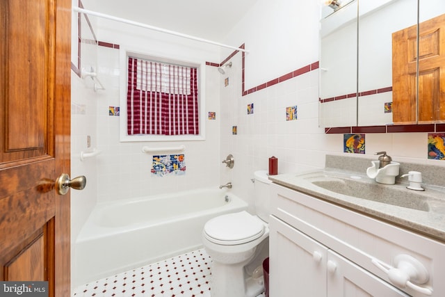 bathroom featuring toilet, vanity, tile walls, and shower / bath combination