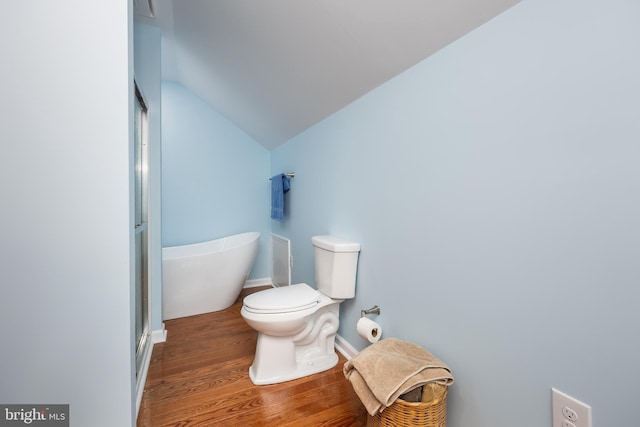 bathroom with a shower with door, toilet, lofted ceiling, wood finished floors, and a soaking tub