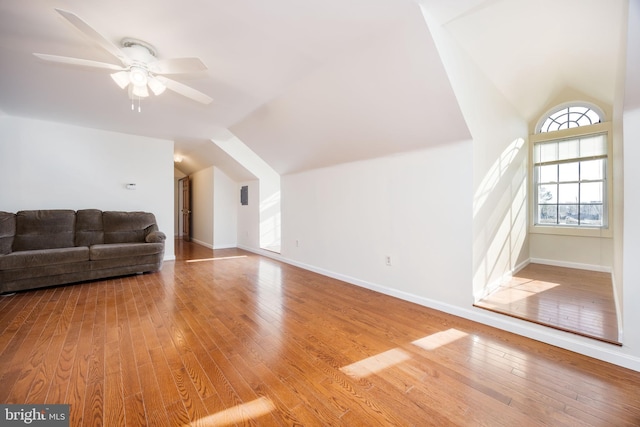 additional living space featuring hardwood / wood-style floors, vaulted ceiling, a ceiling fan, and baseboards