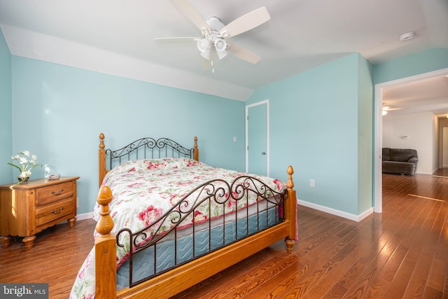 bedroom featuring baseboards, lofted ceiling, and wood finished floors