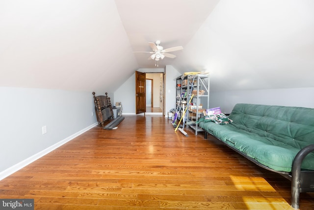 sitting room featuring baseboards, light wood-style flooring, a ceiling fan, and vaulted ceiling