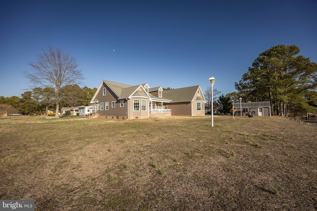 rear view of property featuring crawl space, a lawn, and an outbuilding