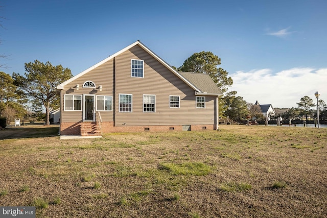 back of house featuring crawl space, entry steps, and a yard