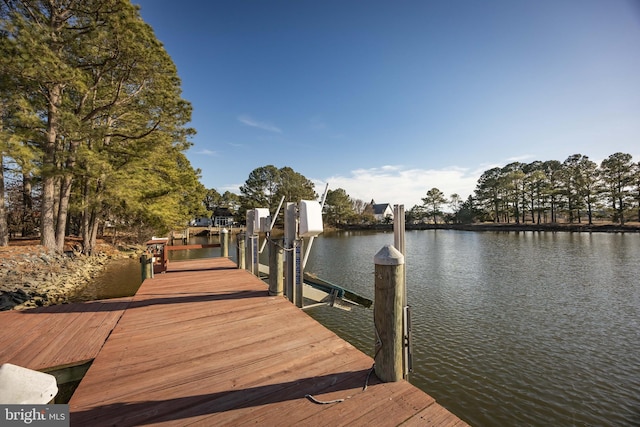 dock area featuring boat lift and a water view